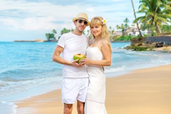 a-man-and-a-girl-on-the-beach-are-drinking-coconut-2023-11-27-05-08-36-utc